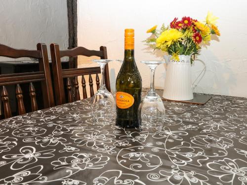 a bottle of wine and two glasses on a table at 1 The Stables in Clitheroe