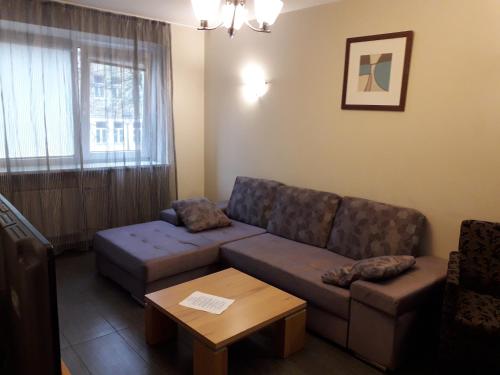 una sala de estar con un sofá y una mesa en Laisves al. 7, en Kaunas