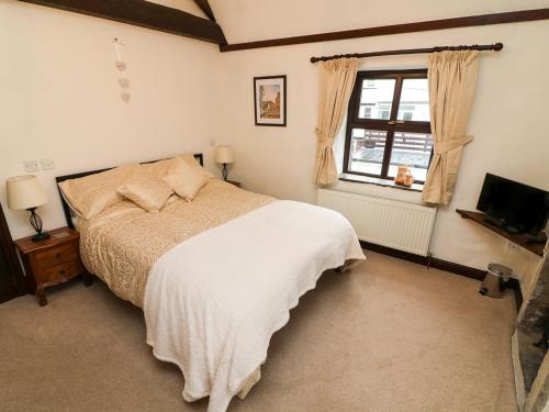 1 dormitorio con cama y ventana en 1 The Stables en Clitheroe
