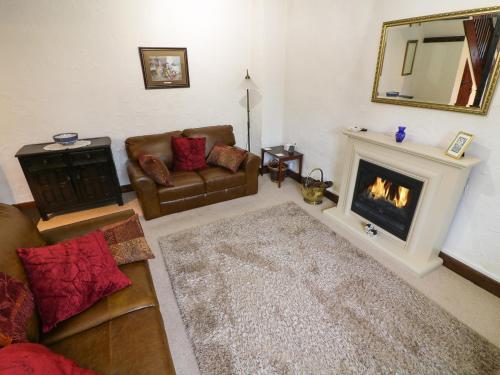 a living room with a couch and a fireplace at 1 The Stables in Clitheroe