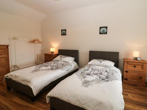 two beds sitting next to each other in a bedroom at Felin Manaw in Bryngwran