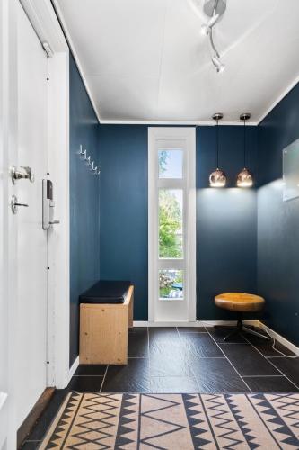 a blue room with a bench and a window at Private House & Bungalow by the sea in Trondheim