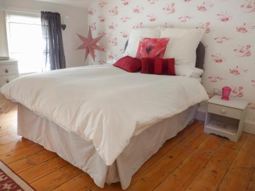 ステイスにあるKippers Cornerのベッドルーム(赤い枕の大きな白いベッド付)