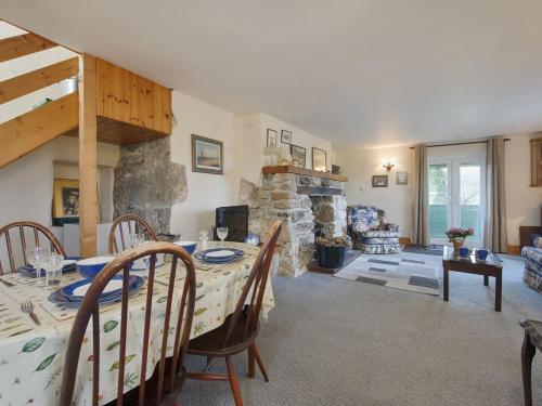 a dining room with a table and a stone fireplace at The Annexe, Higher Lydgate Farmhouse in Postbridge