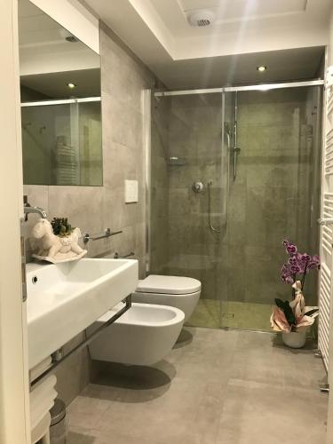 a bathroom with a toilet and a sink and a shower at Hotel Gala in Misano Adriatico