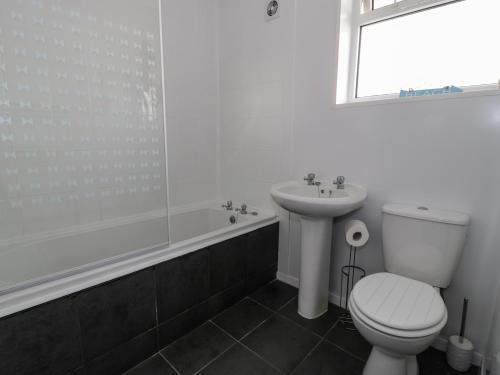 La salle de bains est pourvue de toilettes, d'un lavabo et d'une baignoire. dans l'établissement Sea View, à Benllech