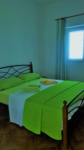 a green bed in a bedroom with a blue wall at Apartments Laura in Stara Baška