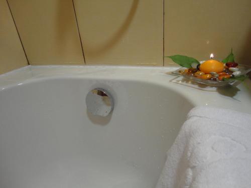 a white bath tub with a plate of fruit on it at Favorit Hotel in Sofia