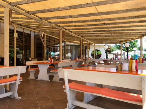 een restaurant met tafels en stoelen en tafels en banken bij Aparthotel Poseidon in Sunny Beach