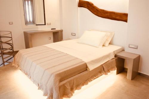 a bedroom with a bed and a stool in it at Aeris suites in Koufonisia