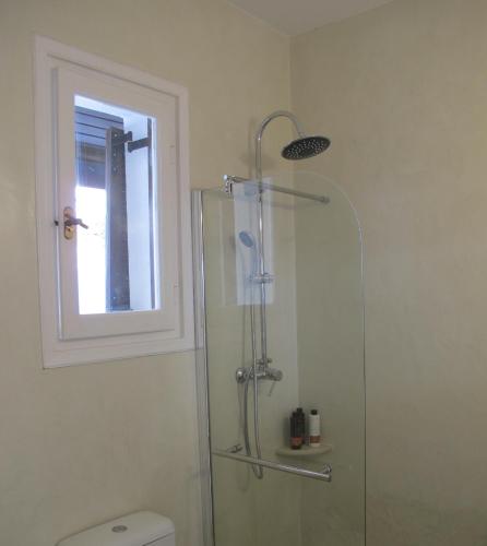a bathroom with a shower and a toilet and a window at Aqua Seafront Glyfada Corfu Beach House With Garden in Glyfada