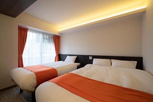 two beds in a room with a window at Terrace Kiyomizu Kyoto in Kyoto