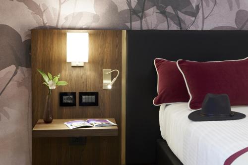 a bedroom with a bed with a red pillow and a lamp at Messori Suites in Florence