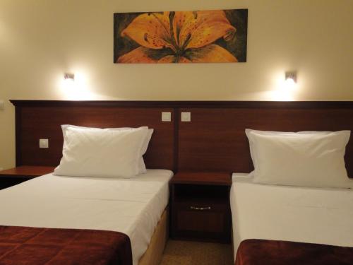 a hotel room with two beds and a painting on the wall at Favorit Hotel in Sofia