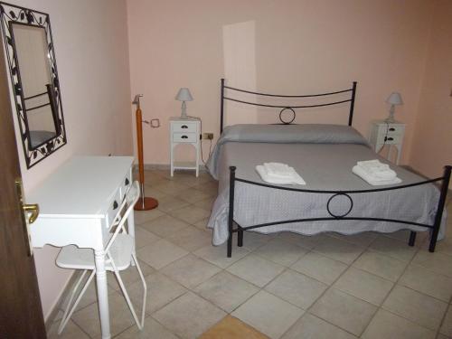 um quarto com uma cama, uma cómoda e um espelho em Casa S'Arriali em Iglesias