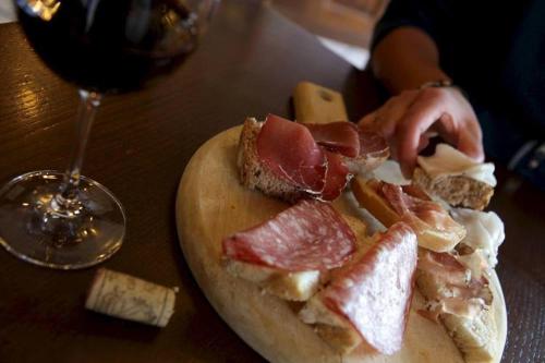 un plato de carne y queso y una copa de vino en Albergo Aprica Garni, en Aprica