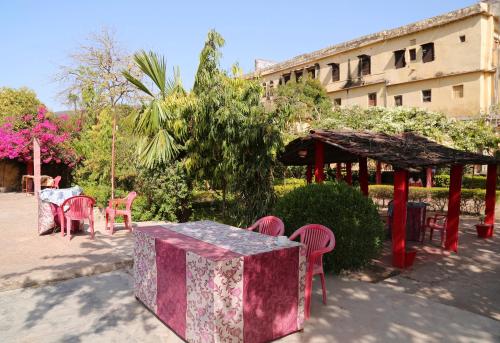 a table and chairs in a courtyard with a building at Haveli Uma Megh Tourist Guest House in Būndi
