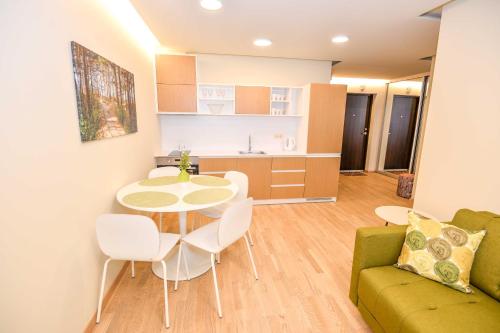 un soggiorno con un tavolo e un divano di Miškas a Palanga