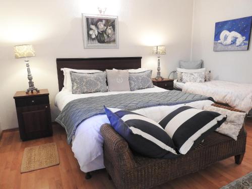 a bedroom with two beds and a chair with pillows at New Stone Manor in Mossel Bay