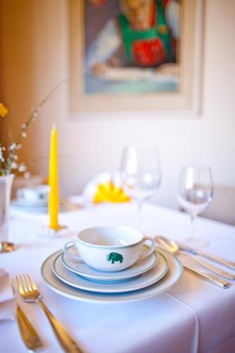 a table with a bowl and plates on a table at Hotel Elefant in Ora/Auer