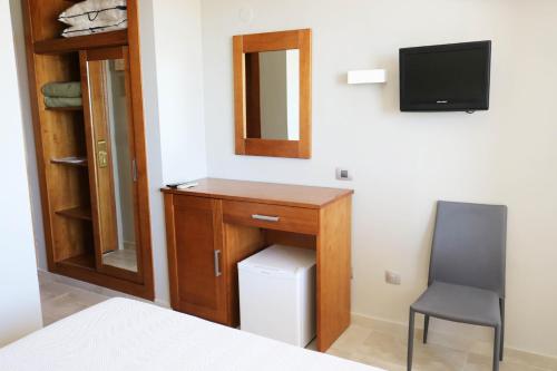 a bedroom with a desk and a chair and a television at Hotel Costa Azahar in Grao de Castellón