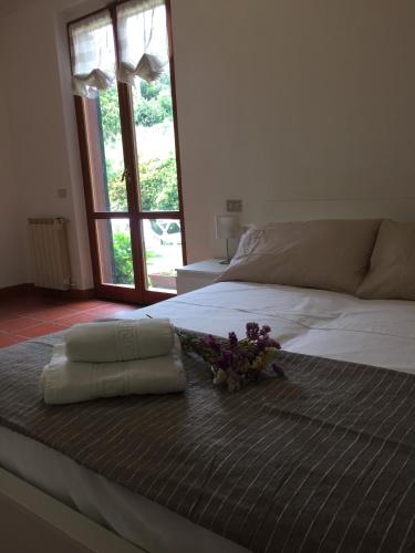 a white bed with a bunch of flowers on it at Villa Luli in Portovenere