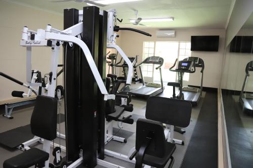 a gym with several tread machines in a room at Park Hotel Mokopane in Mokopane