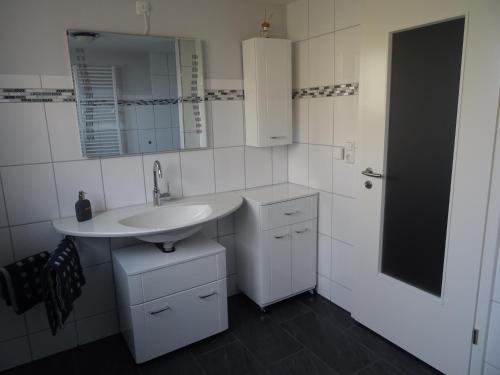 bagno bianco con lavandino e specchio di Apartment Staudacker a Drage