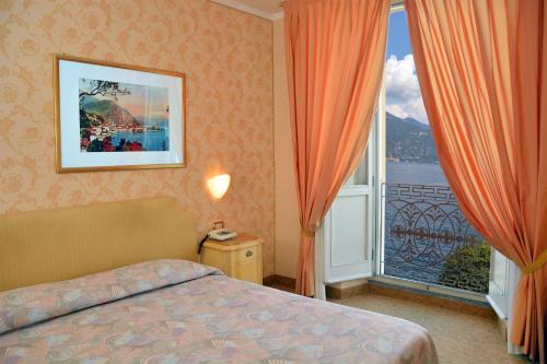 Tempat tidur dalam kamar di Grand Hotel Menaggio