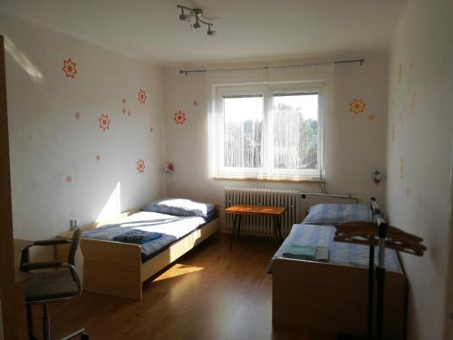 a bedroom with two beds and a window at Apartment Pražská in Rokycany