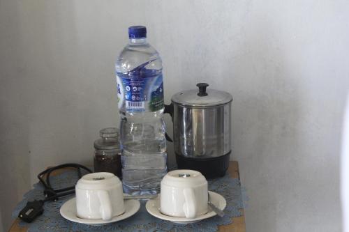 a bottle of water and two cups and a blender at Aryautama Garden Villa in Munduk