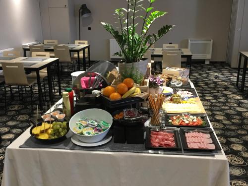 a table topped with plates of food and drinks at Hotel Center Novo Mesto in Novo Mesto