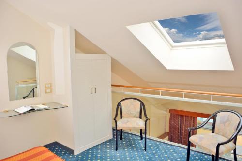 a room with two chairs and a skylight at Grand Hotel Menaggio in Menaggio