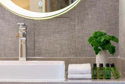 eine Badezimmertheke mit Waschbecken und eine Vase mit Pflanze in der Unterkunft Moon Villa in Yangshuo