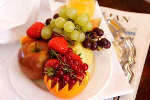 a white plate with fruit on a table at Best Western Ipswich Hotel in Ipswich
