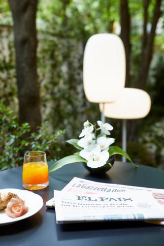 a table with a plate of food and a glass of orange juice at Messori Suites in Florence