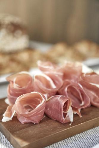 a pile of meat on a wooden cutting board at Messori Suites in Florence