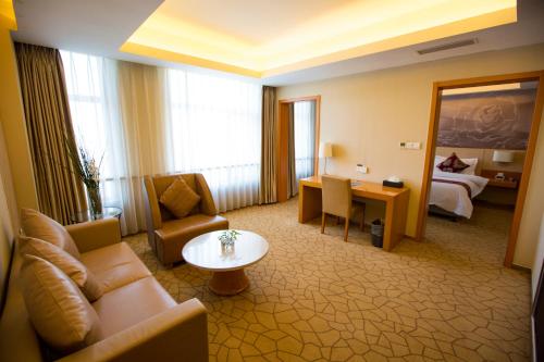 a hotel room with a couch and a table and a bed at Metropolo Shenyang Wanda Plaza-Beiyi Road in Shenyang