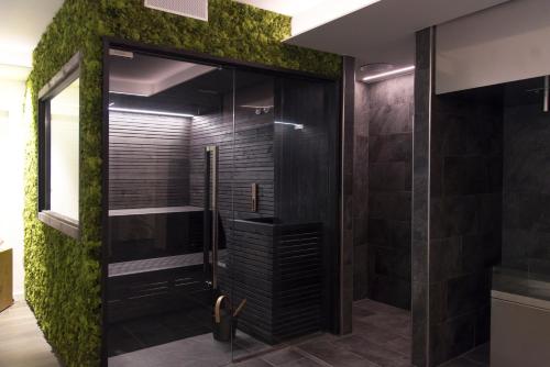 baño con ducha con musgo verde en la pared en Garda Hotel Forte Charme en Nago-Torbole