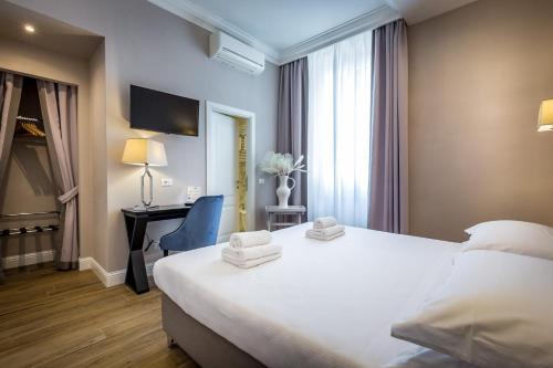 a hotel room with a white bed and a desk at Hotel Emma Small Luxury Hotel in Florence