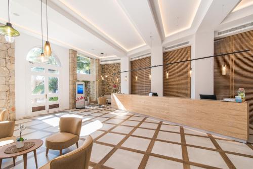 a lobby of a hotel with chairs and a reception desk at Hotel Na Taconera in Cala Ratjada