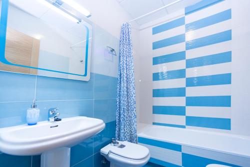 マラガにあるLivemalaga Apartment & Parkingの青と白のバスルーム(洗面台、トイレ付)