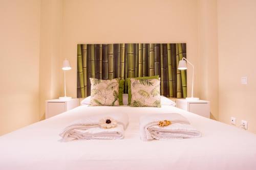 マラガにあるLivemalaga Apartment & Parkingのベッドルーム1室(白いベッド1台、タオル付)