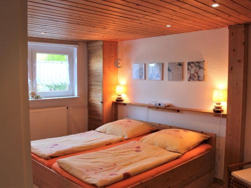 two beds in a room with a window and two lamps at Beautiful Apartment in Damshagen near the Sea in Damshagen