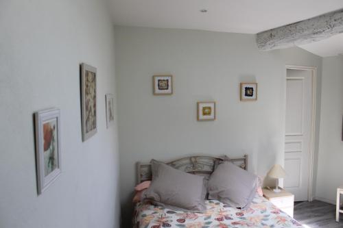 a bedroom with a bed with pictures on the wall at Dans un écrin de Nature in Montclar