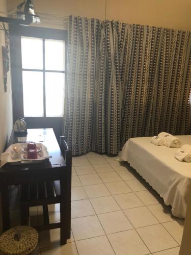 a room with a bed and a table and a window at Hotel Central in São Tomé