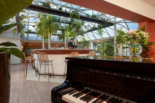 a piano in a restaurant with a bar at Villa Duflot Hôtel & Spa Perpignan in Perpignan