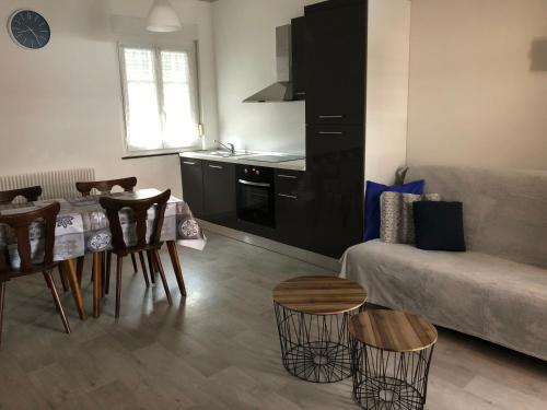 une cuisine et un salon avec une table et un canapé dans l'établissement Gite des cigognes bleu, à Mittelwihr