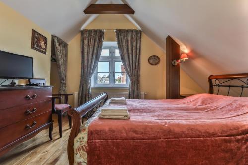 a bedroom with a bed with a dresser and a window at Vila 1956 in Palanga