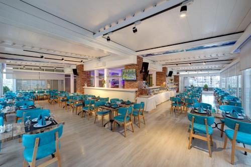 una sala da pranzo con tavoli e sedie blu di Forum Suite Otel a Mersin